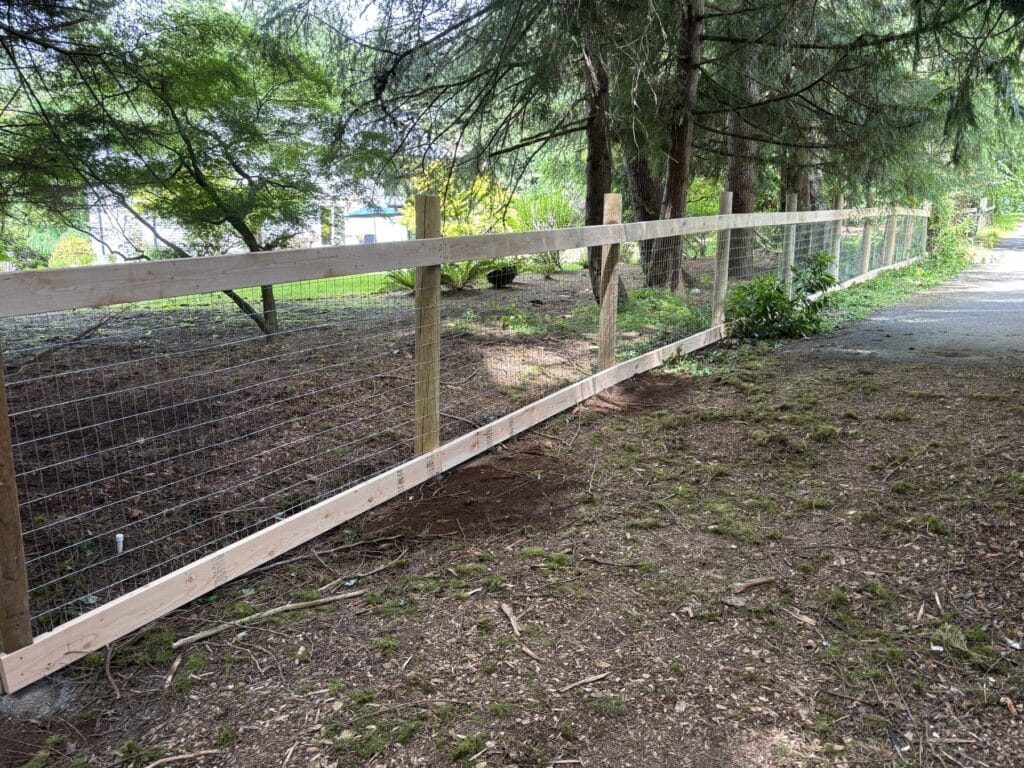 Hog wire fence with round wood posts installed by Golden Fence in Woodinville